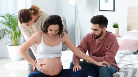 donna che si prepara ad affrontare il dolore del parto con l'aiuto del compagno e dell'ostetrica a casa